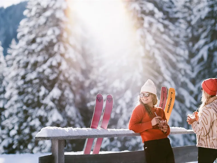 Skifahrer machen Pause bei Alm im verschneiten Saalbach 
