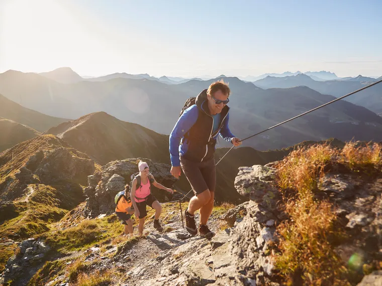Wanderer die den Berg im Herbst besteigen