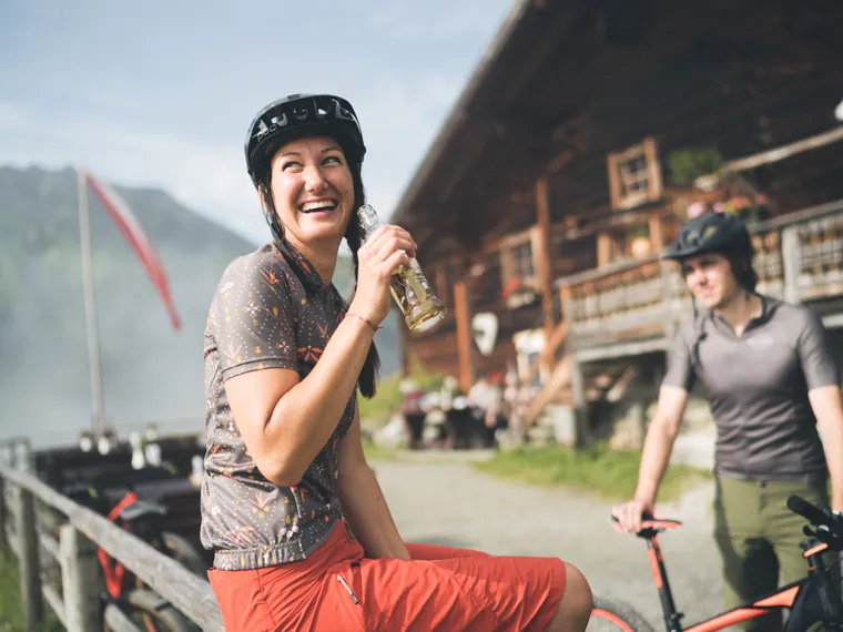 Mountainbiker machen Pause auf Alm