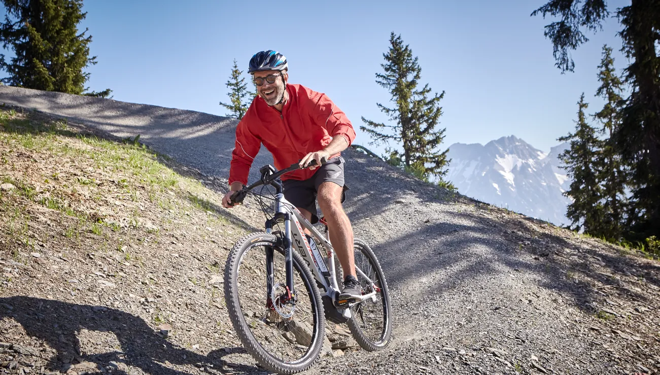 Downhiller auf einem Trail in Saalbach Hinterglemm
