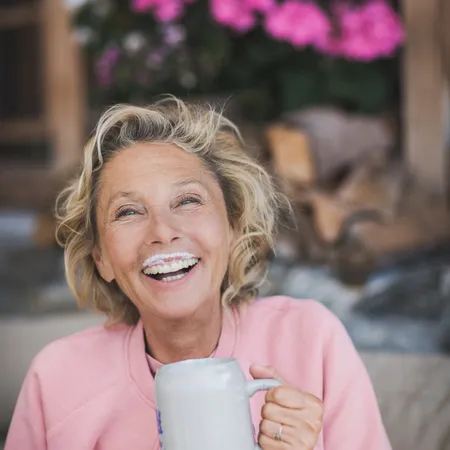 Frau beim Kaffee trinken und am lachen 