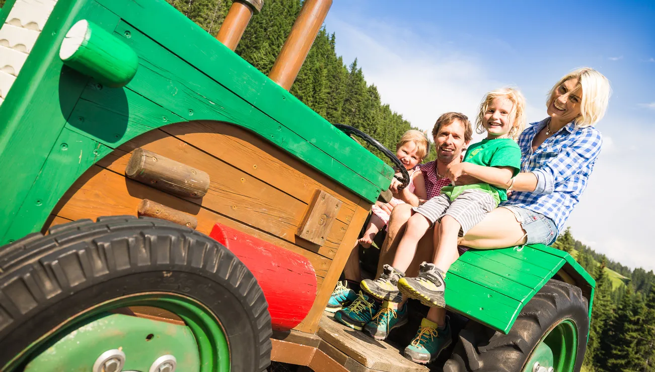 Familie auf einem Traktor am Montelino Erlebnisweg