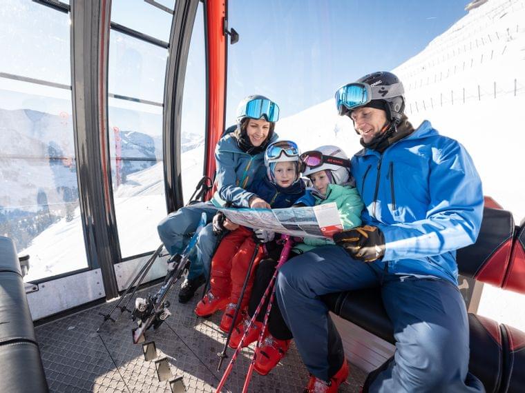 Familie beim Skifahren in einer Gondel