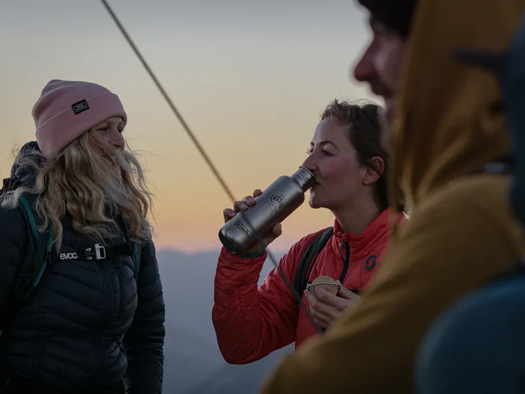 Wanderer machen Pause am Berg bei Sonnenuntergang
